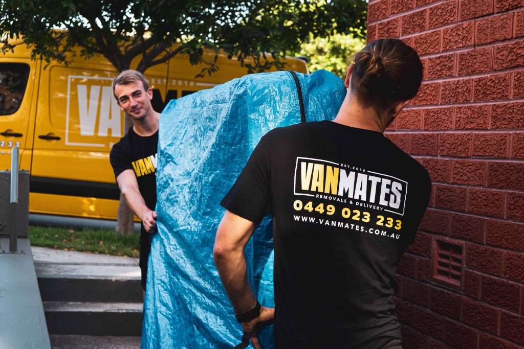 Two home removalists carrying mattress in mattress bag